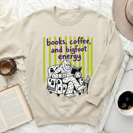 Bigfoot reading a book with "books, coffee, and bigfoot energy".