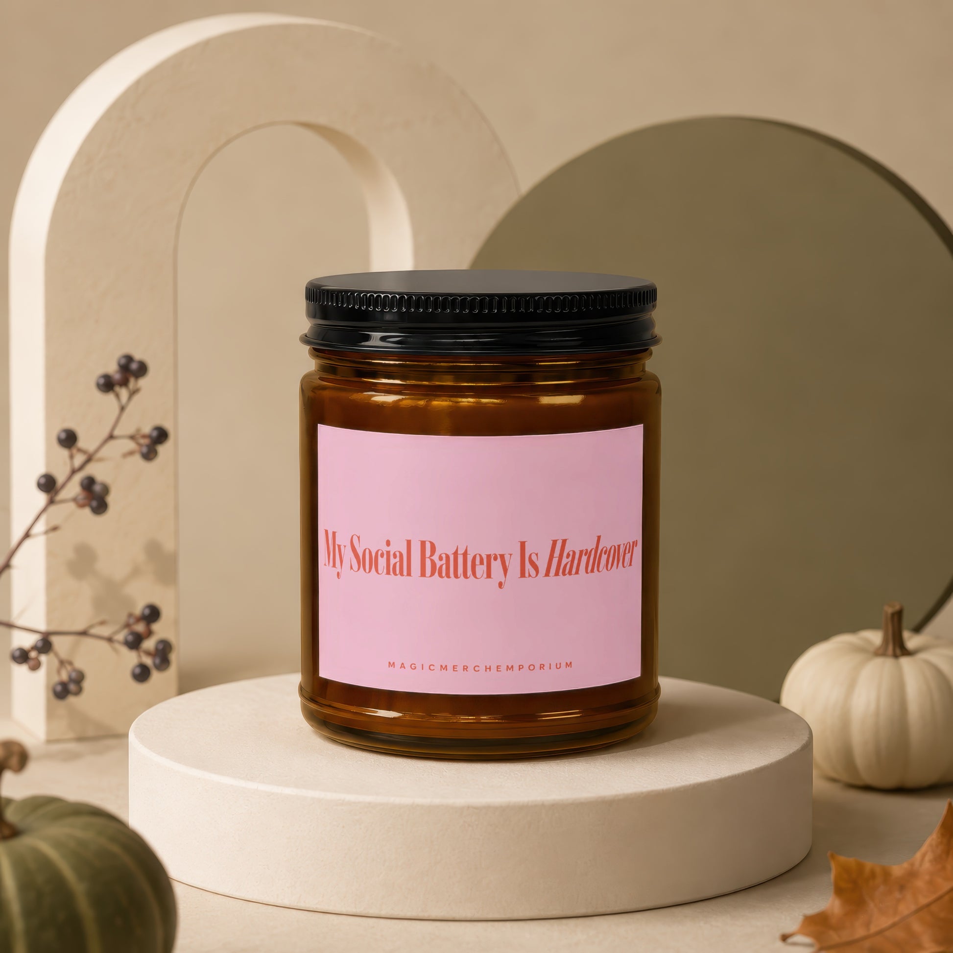 Amber jar candle with pink label reading "My Social Battery Is Hardcover".