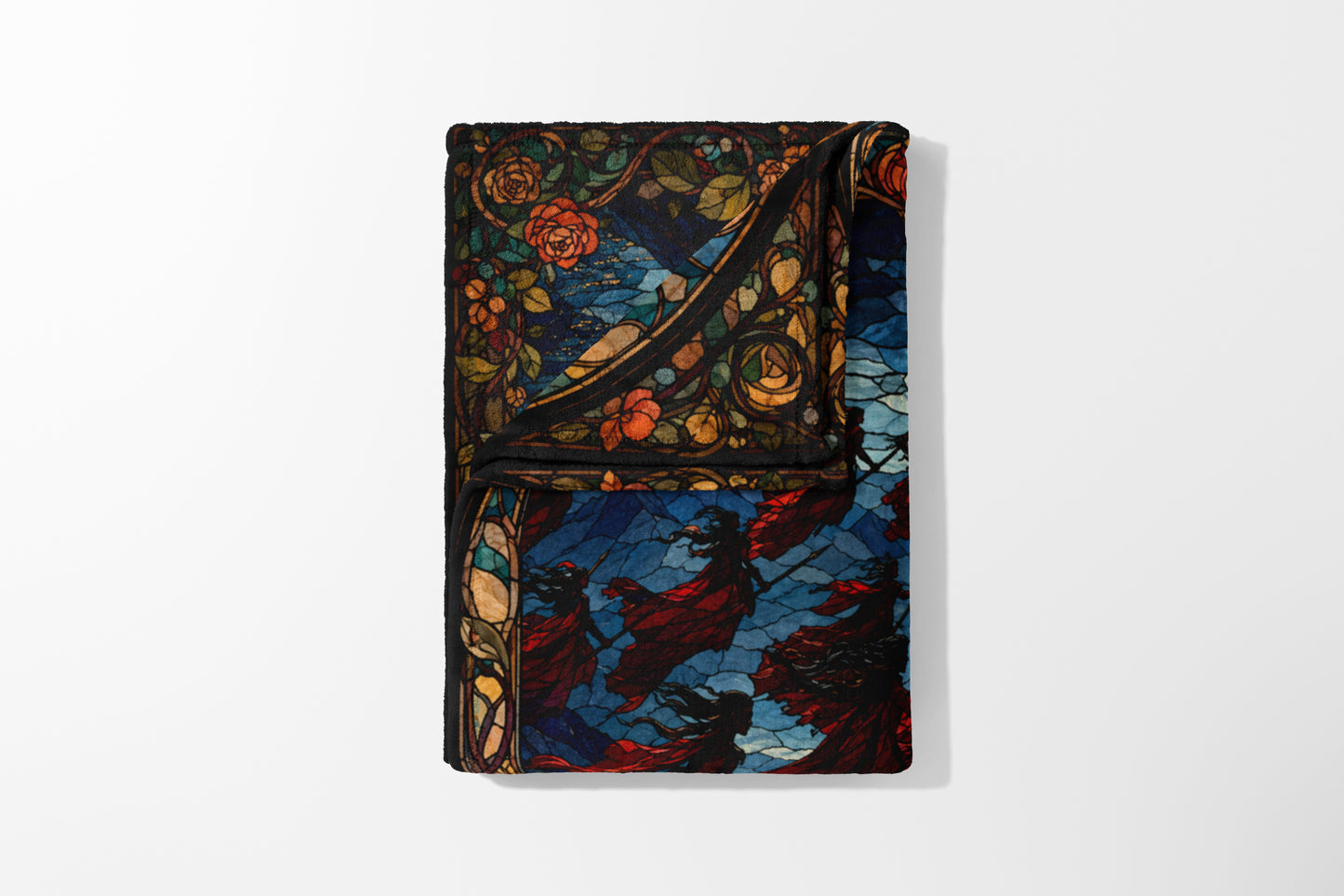 Folded blanket with stained glass design of roses and figures in red cloaks.