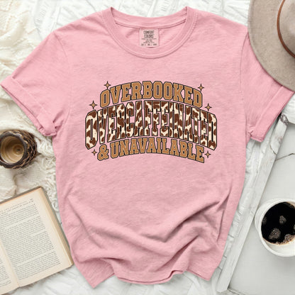 Pink t-shirt with "Overbooked Overcaffeinated & Unavailable" graphic.