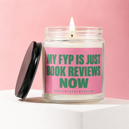 Glass candle with lit wick and pink label reading "MY FYP IS JUST BOOK REVIEWS NOW".