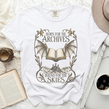White t-shirt with "Born for the Archives, Bound for the Skies" text and fantasy book illustration.