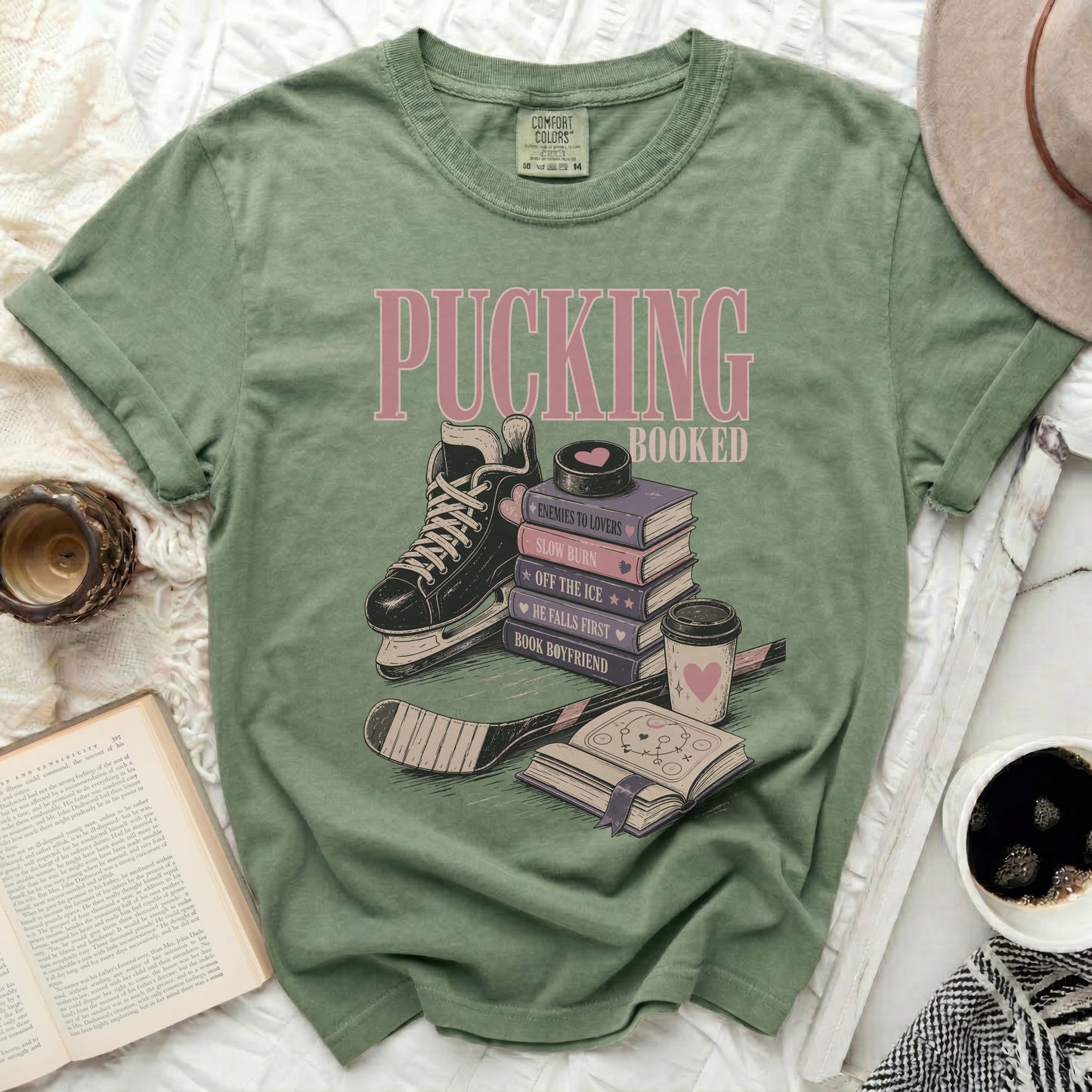 Green t-shirt with "Pucking Booked" and book titles: Enemies to Lovers, Slow Burn, Off the Ice.