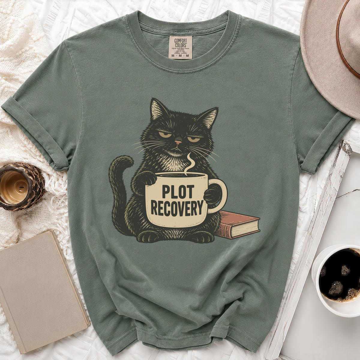 Black cat with grumpy expression holding mug that says "Plot Recovery".