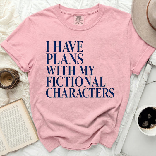 Pink t-shirt with dark blue text "I HAVE PLANS WITH MY FICTIONAL CHARACTERS."