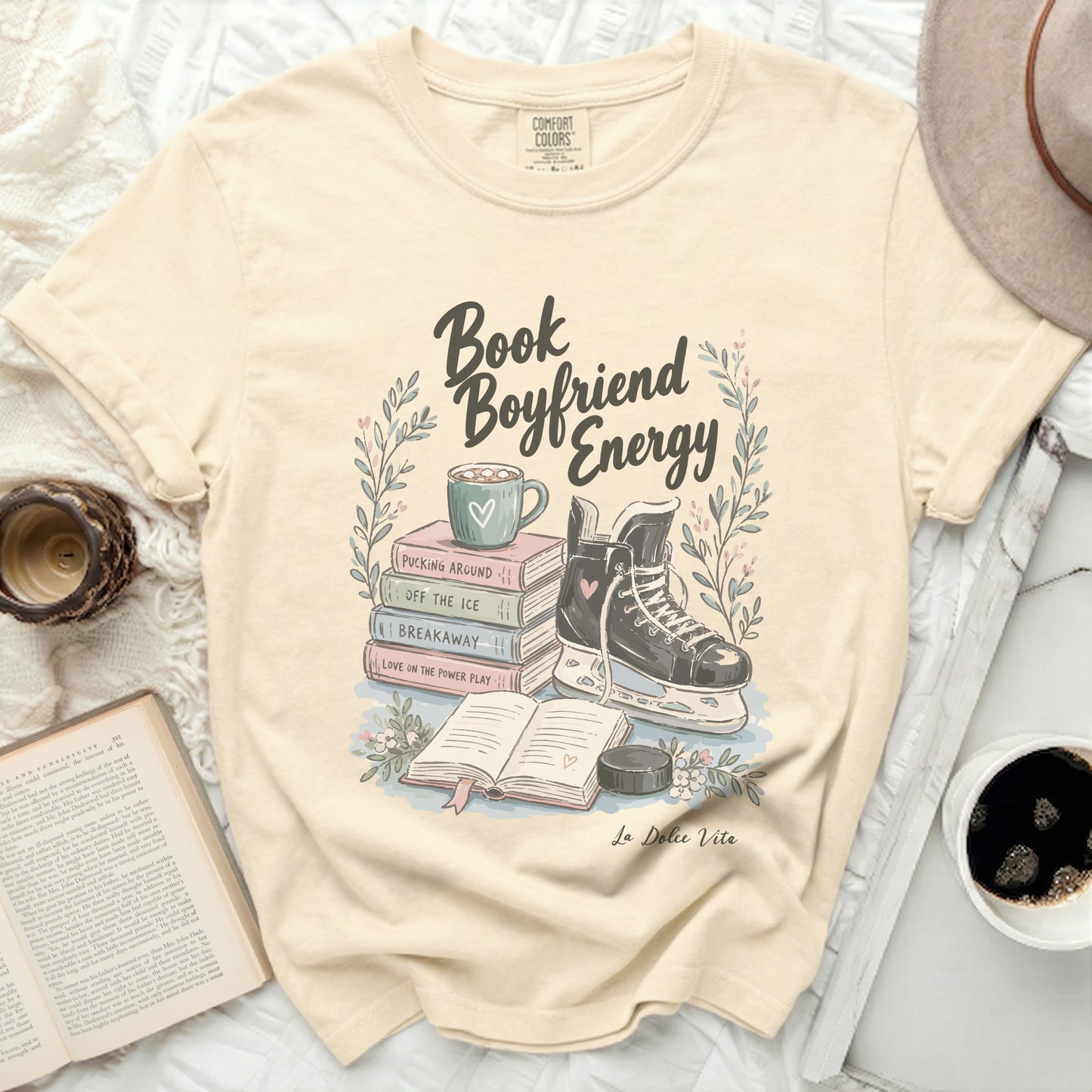 Cream t-shirt with "Book Boyfriend Energy" graphic and ice skating elements.