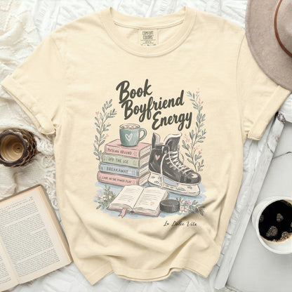 Cream t-shirt with "Book Boyfriend Energy" graphic and ice skating elements.