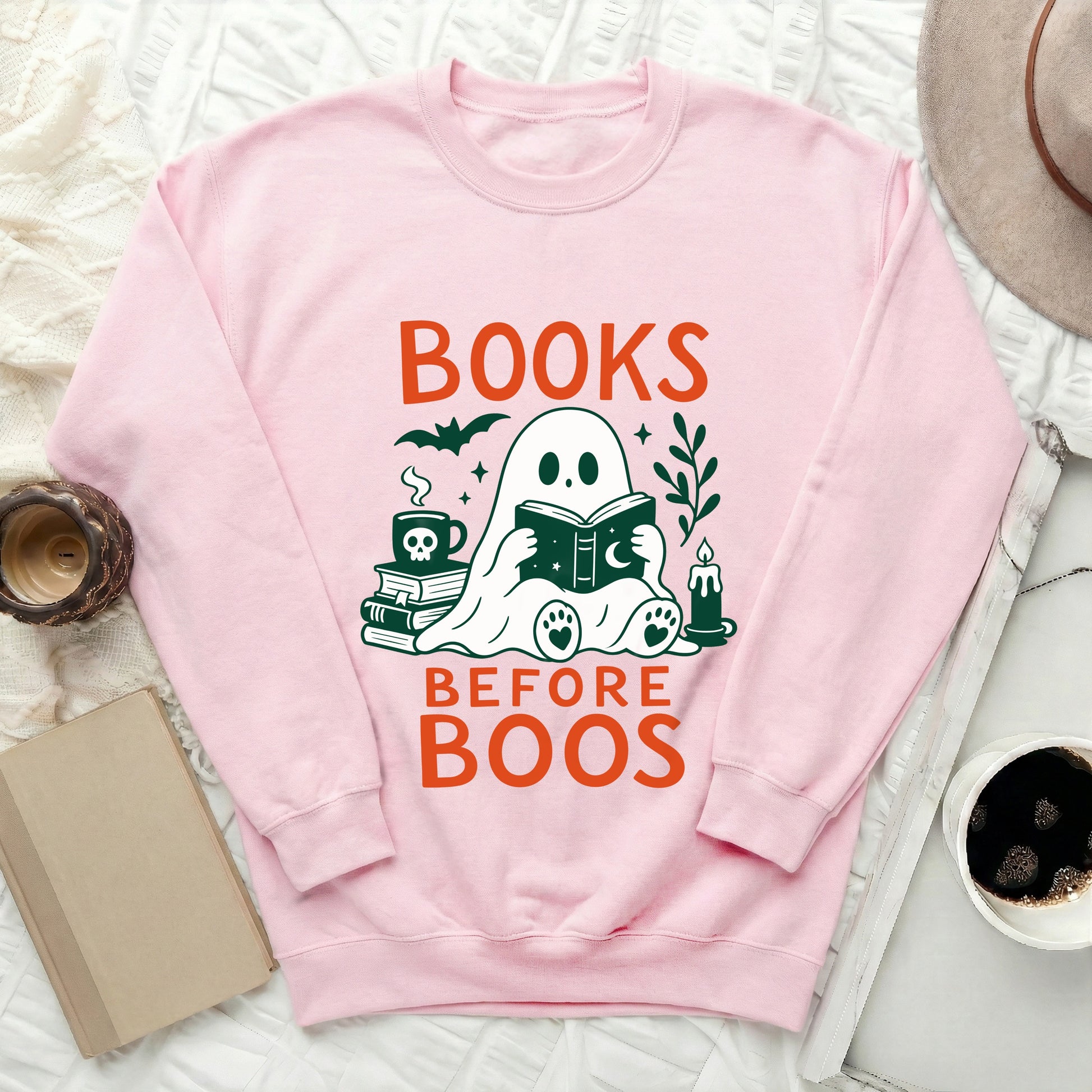 Pink sweatshirt with "BOOKS BEFORE BOOS" text and a ghost reading a book.