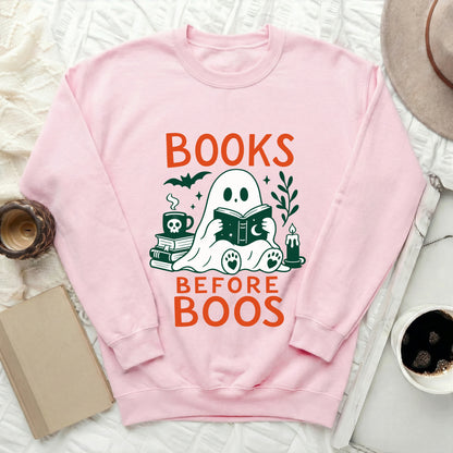 Pink sweatshirt with "BOOKS BEFORE BOOS" text and a ghost reading a book.