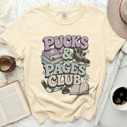 Cream t-shirt with "Pucks & Pages Club" graphic and book and hockey imagery.