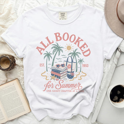White t-shirt with "All Booked for Summer" text and beach imagery.