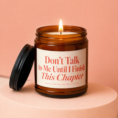 Amber jar candle with lit flame and black lid, reads "Don't Talk to Me Until I Finish This Chapter."