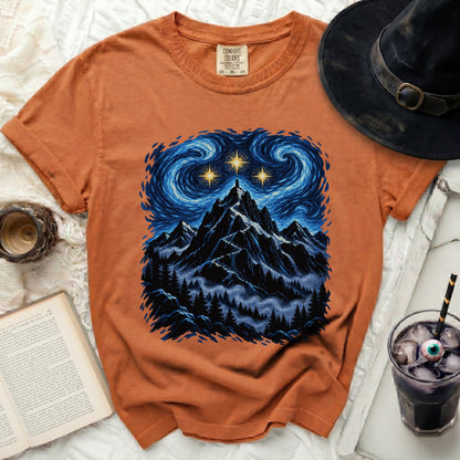 Orange t-shirt with mountain and starry night graphic.