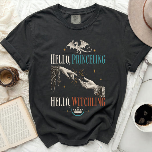 Dark t-shirt with dragon, hands reaching, and "Hello, Princeling, Hello, Witchling" text.