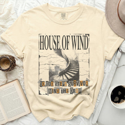 Cream t-shirt with "House of Wind 10,000 Steps Survivor Mind the Drop" graphic.