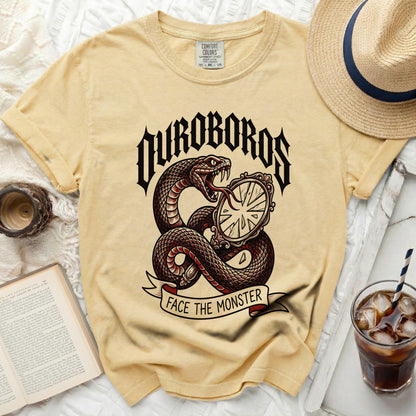 Yellow t-shirt with snake, mirror, and "OUROBOROS FACE THE MONSTER" graphic.