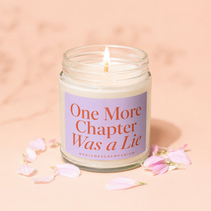 Candle with "One More Chapter Was a Lie" text on lavender label, lit flame.