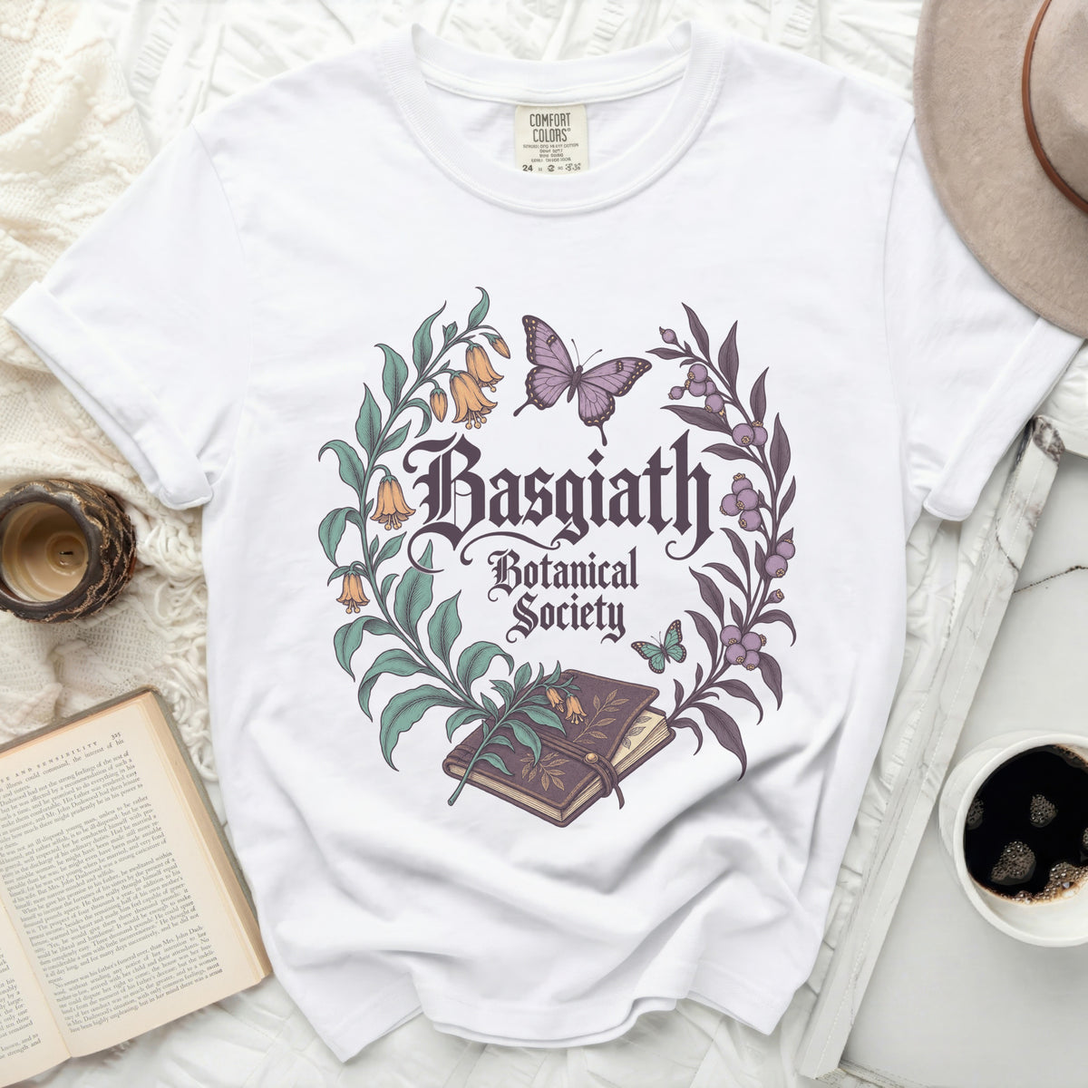 White t-shirt with "Basgiath Botanical Society" text surrounded by floral and butterfly graphics.