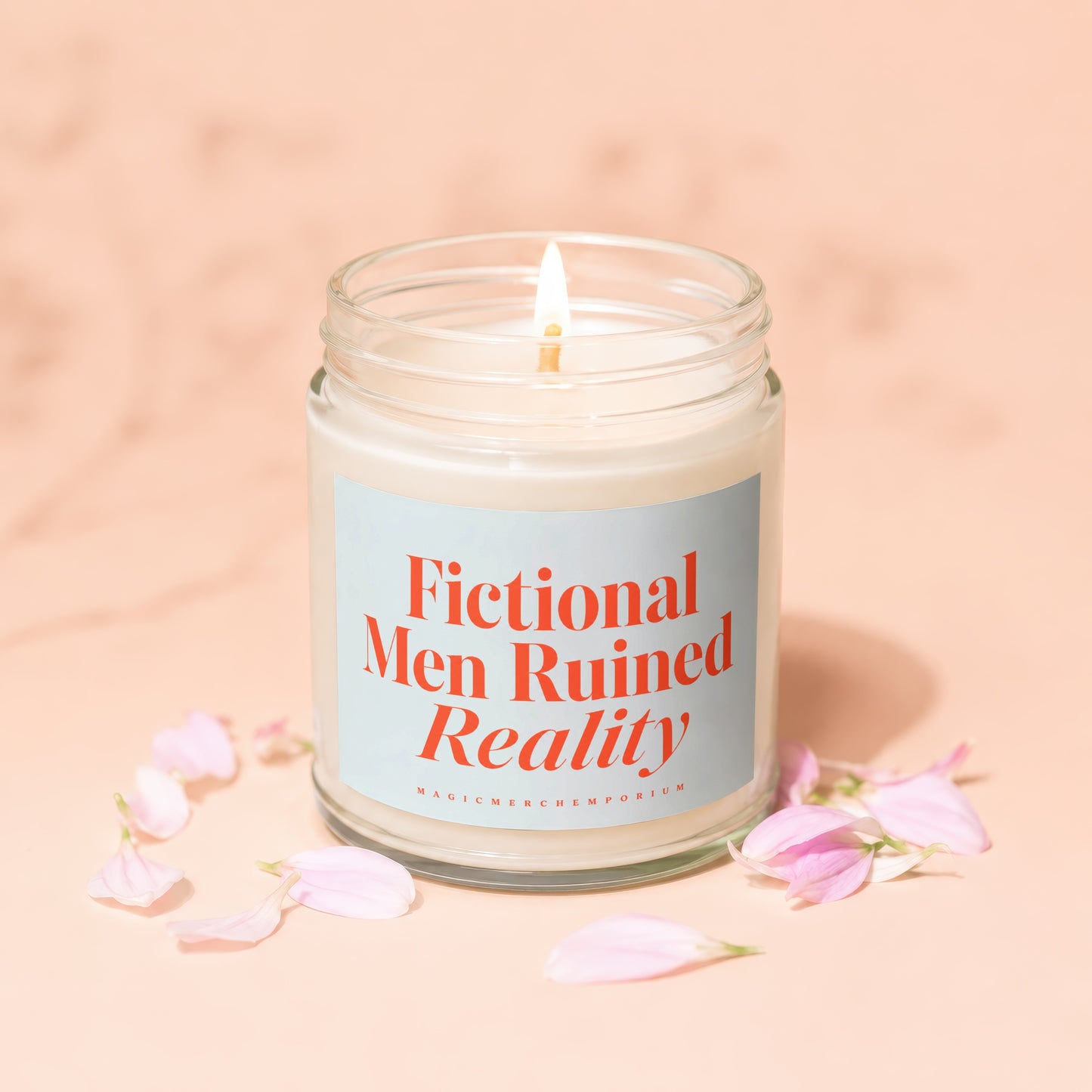 Lit candle in a glass jar with "Fictional Men Ruined Reality" text on a pale blue label.