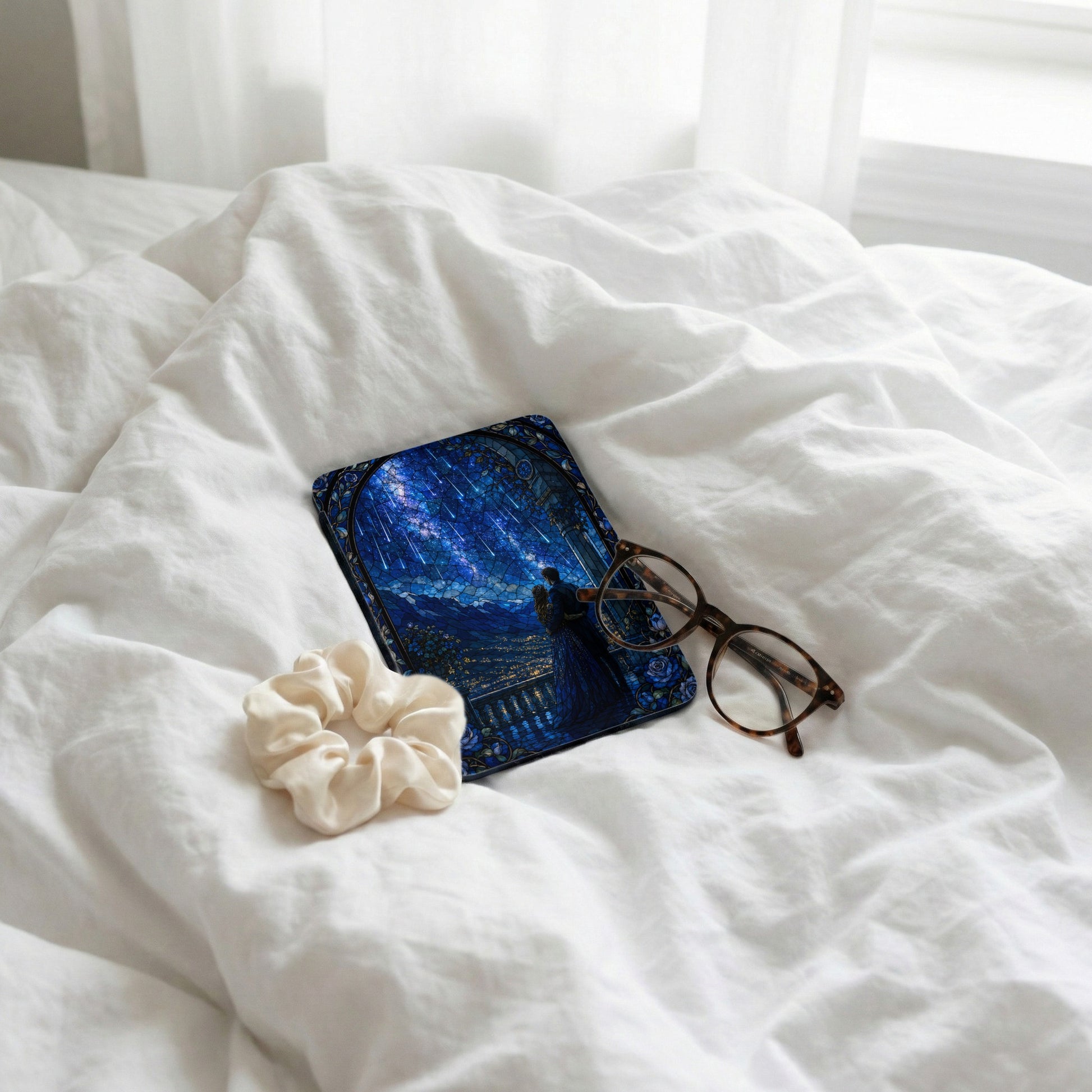 Stained glass art tablet, glasses, and scrunchie on white linen.