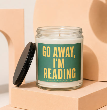Glass jar candle with green label reading "GO AWAY, I'M READING".