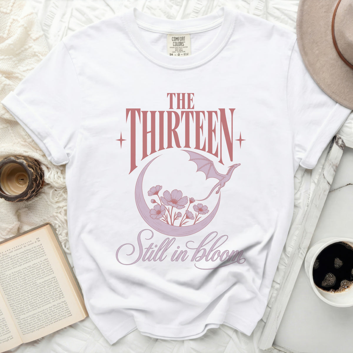 White t-shirt with "The Thirteen Still in bloom" text and dragon moon graphic.
