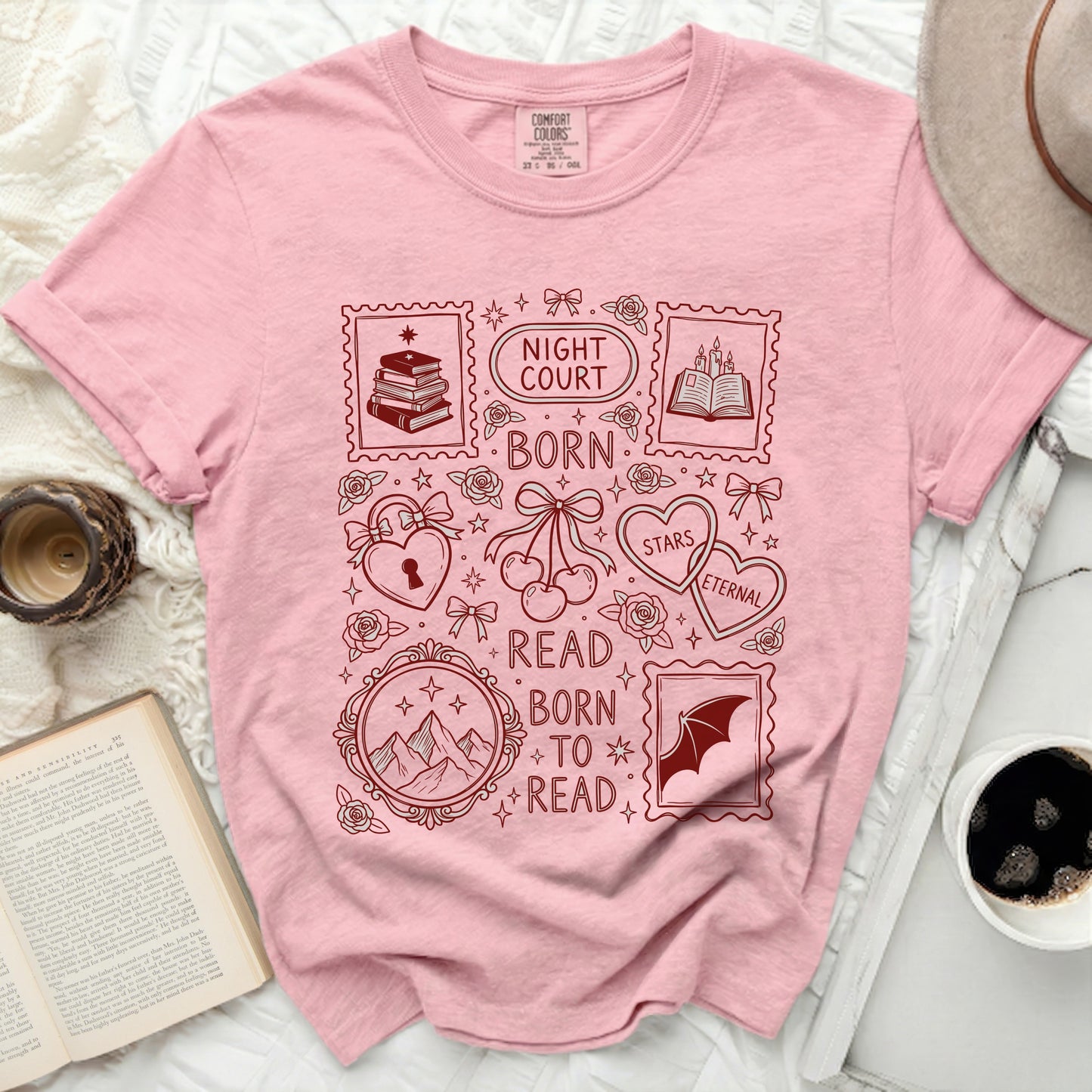 Pink t-shirt with stamp-like graphic elements and book-themed text.