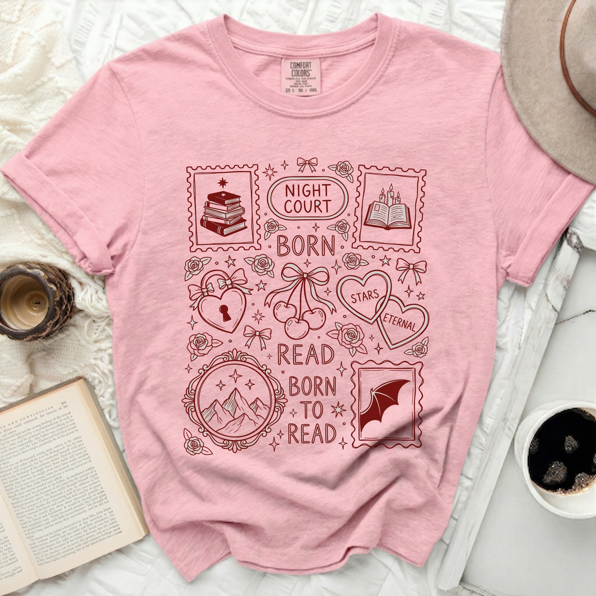 Pink t-shirt with stamp-like graphic elements and book-themed text.