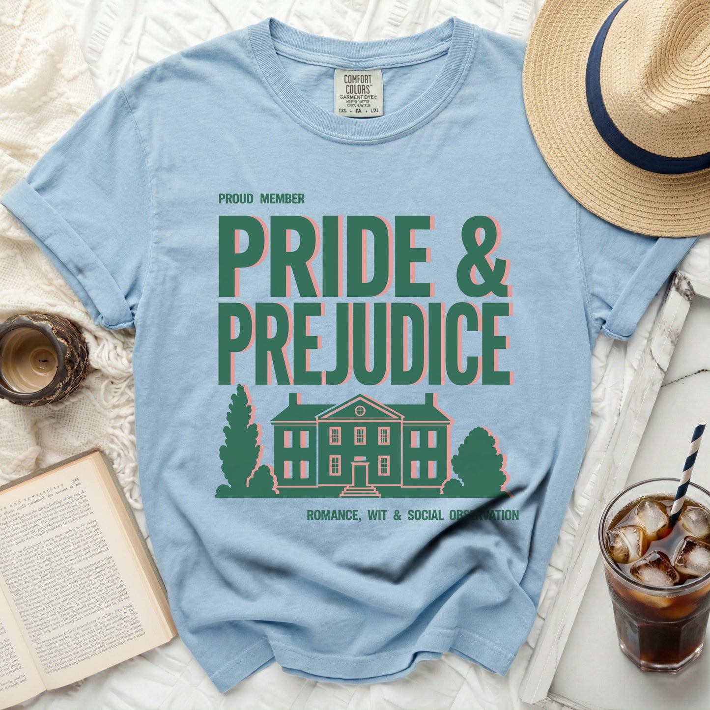 Light blue t-shirt with "Pride & Prejudice" text and a house graphic.