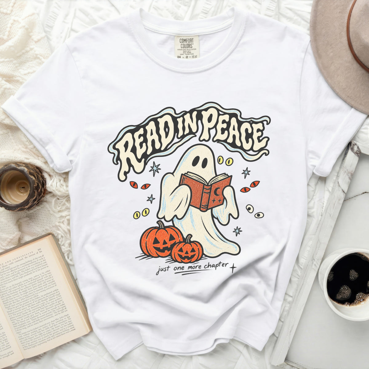 White t-shirt with ghost reading a book, pumpkins, and text "READ IN PEACE".