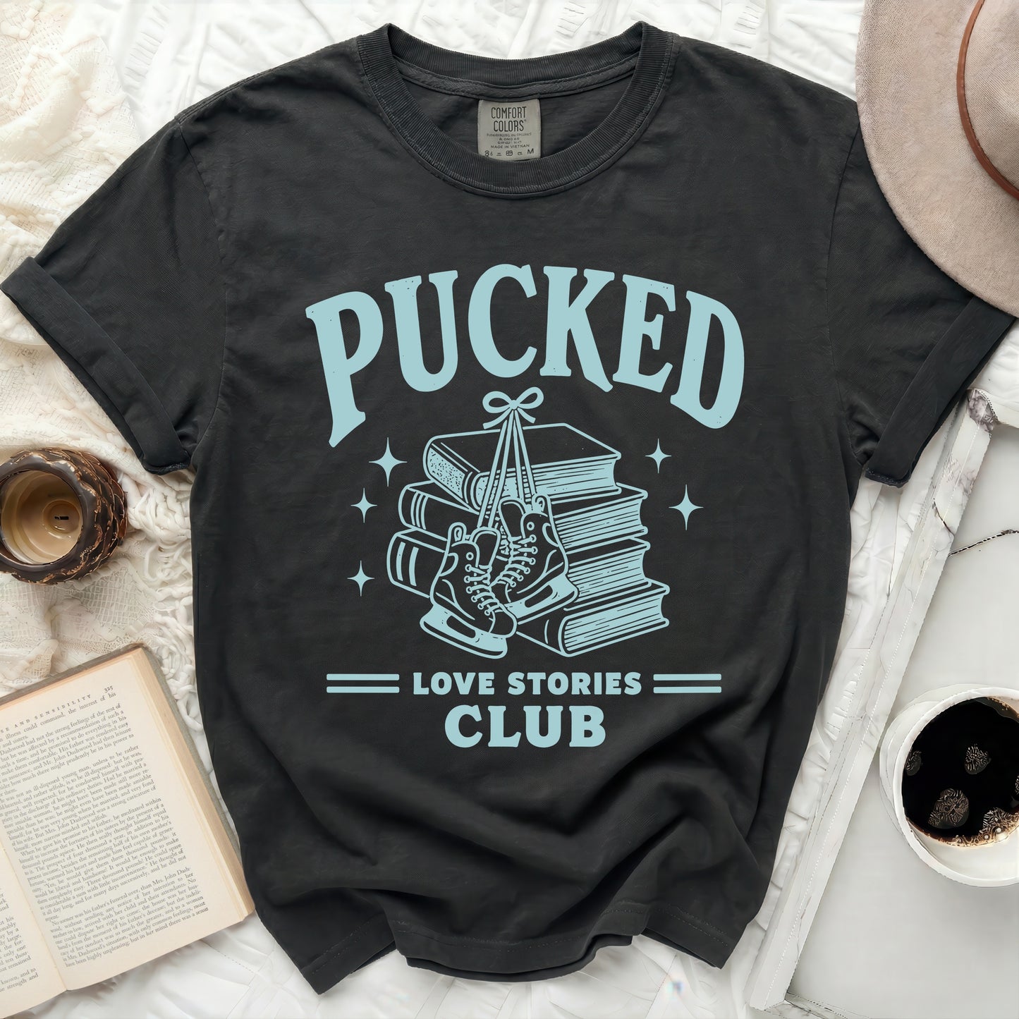 Dark t-shirt with "Pucked Love Stories Club" and ice skates on books.