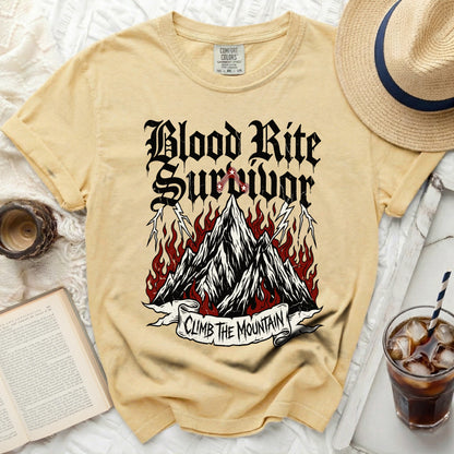 Yellow Comfort Colors t-shirt with "Blood Rite Survivor" and mountains graphic.