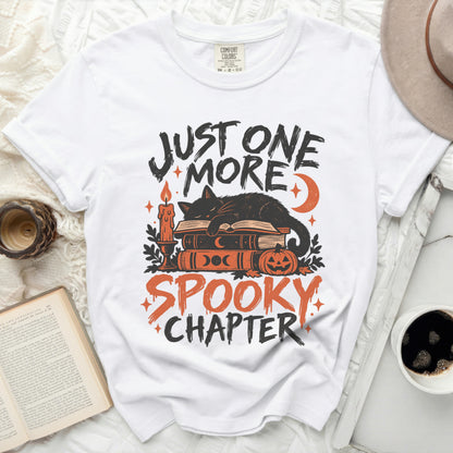 White t-shirt with "Just One More Spooky Chapter" Halloween graphic.