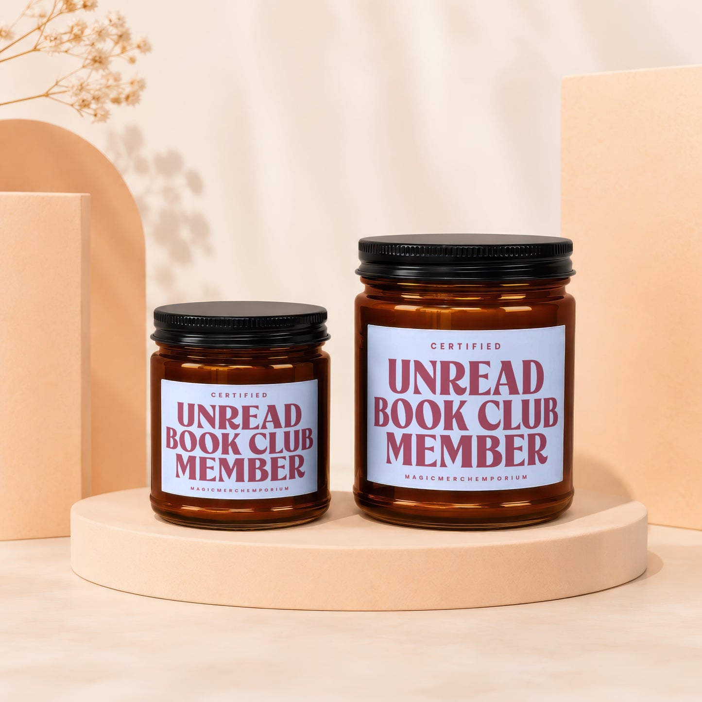 Two amber glass candles with black lids and "Unread Book Club Member" labels.