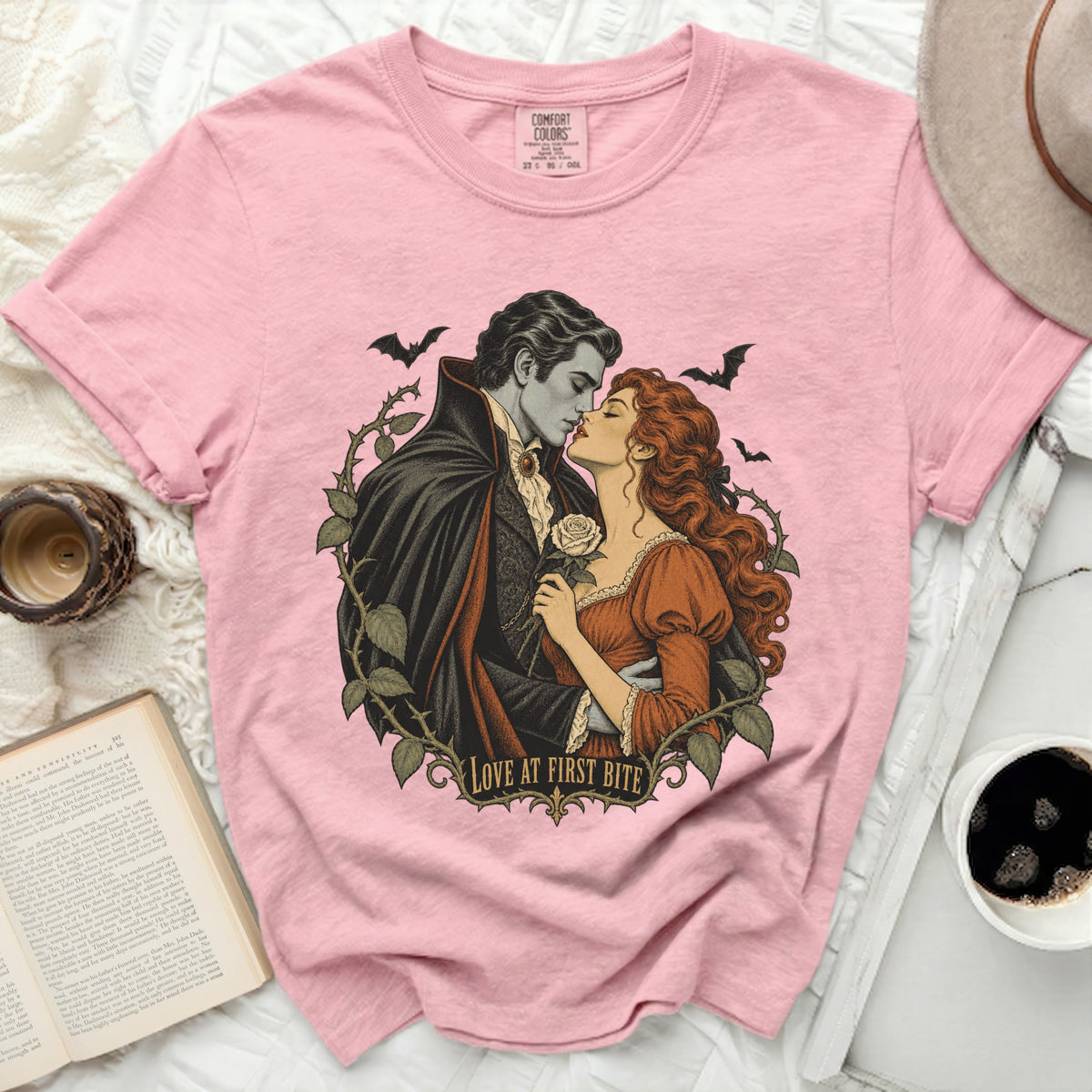 Pink t-shirt with vampire couple kissing, roses, bats, and "Love at First Bite" text.