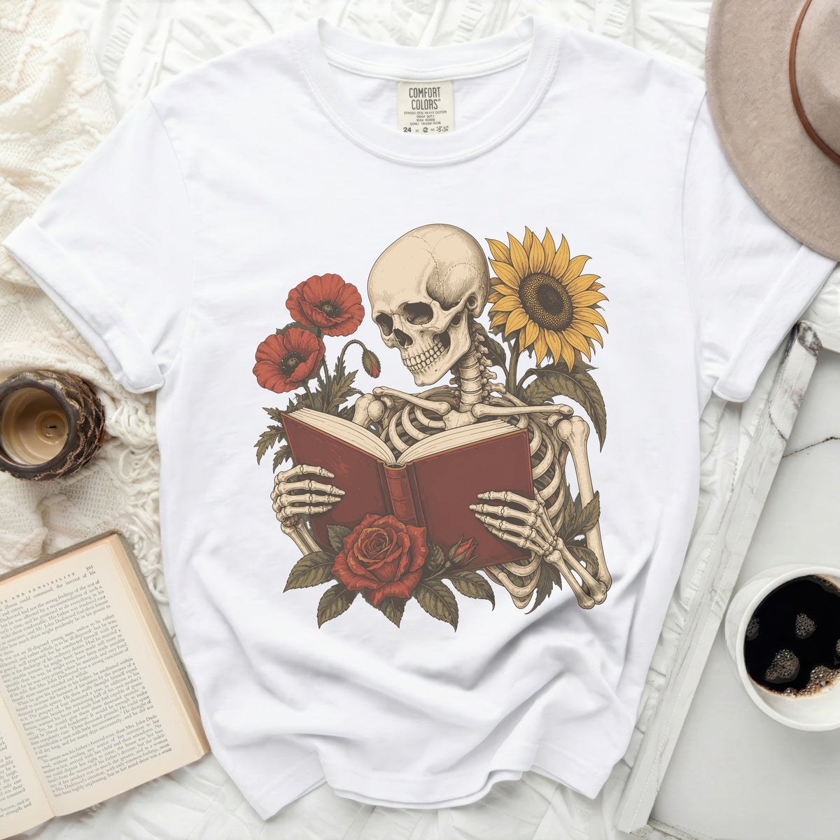 Skeleton reading a book with poppies and a sunflower.