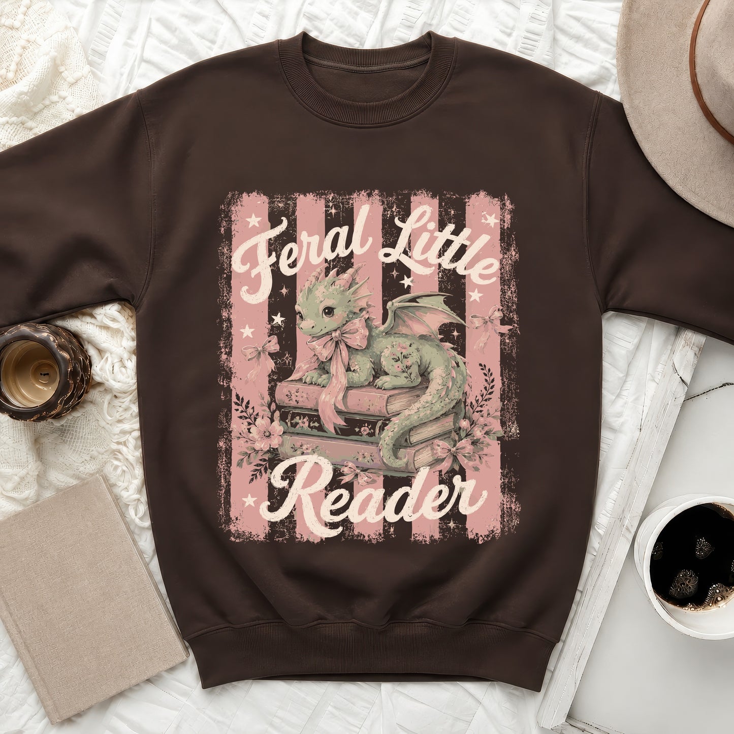 Brown sweatshirt with "Feral Little Reader" text and a dragon graphic.