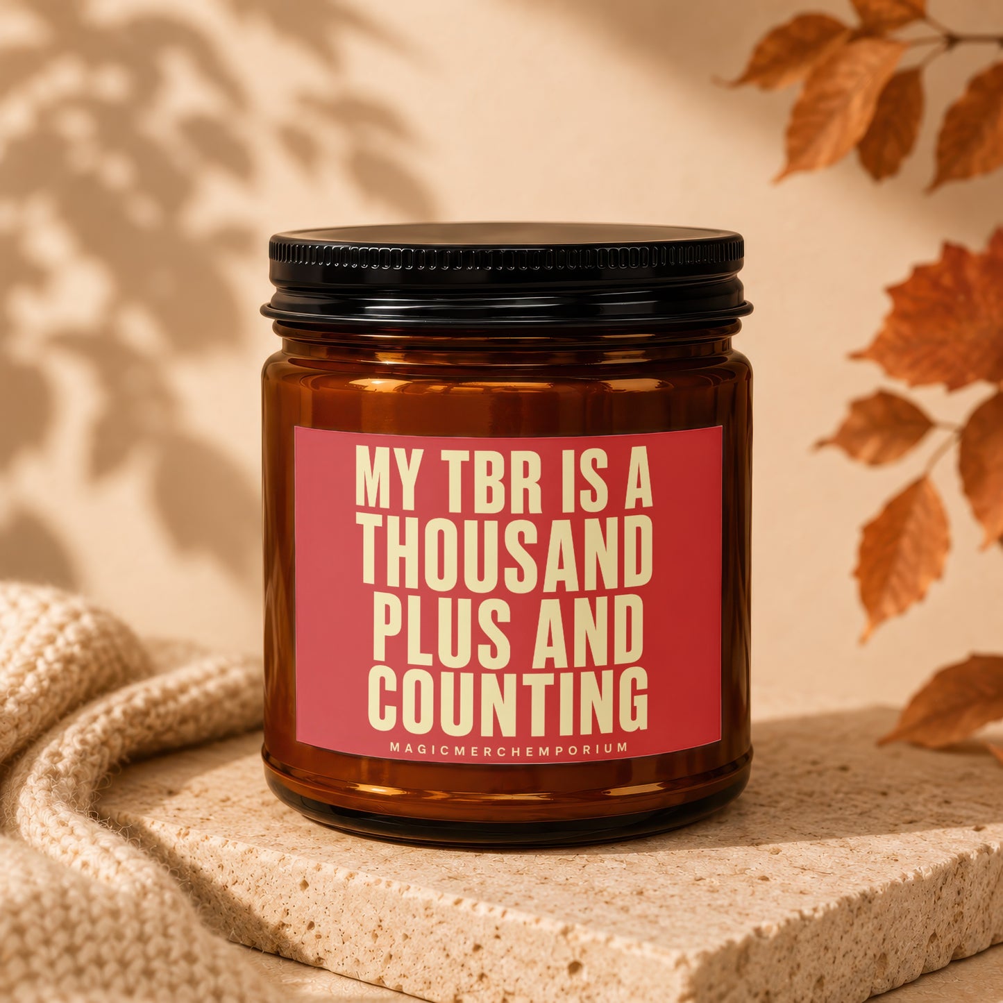 Amber jar candle with red label reading "MY TBR IS A THOUSAND PLUS AND COUNTING".