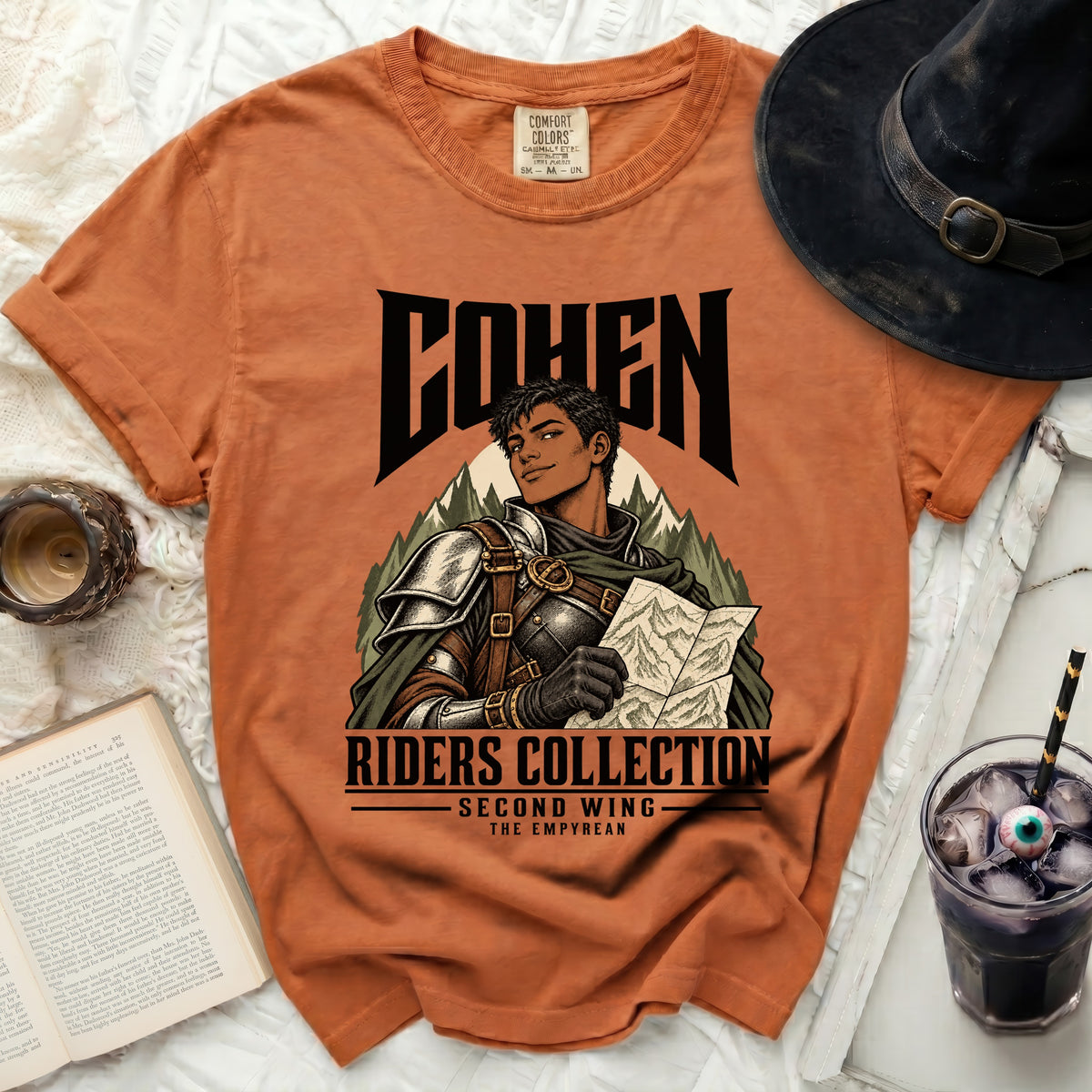 Orange t-shirt featuring "COHEN RIDERS COLLECTION SECOND WING THE EMPYREAN" text and artwork.