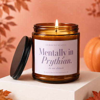 Amber candle with lit wick, lid removed. Label reads "Mentally in Prythian. do not disturb."