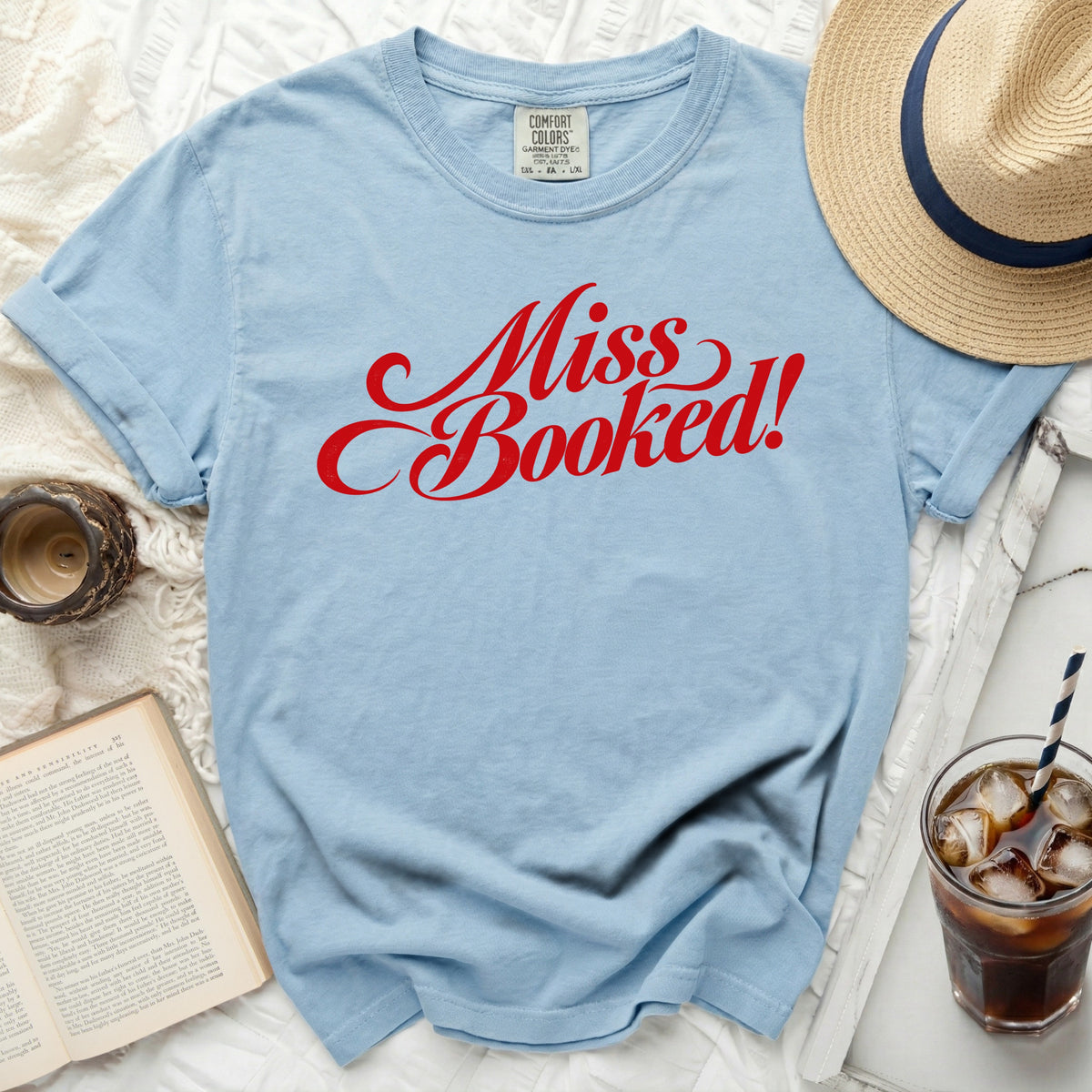 Light blue t-shirt with red cursive text "Miss Booked!"
