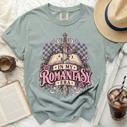 Light blue t-shirt with "In My Romantasy Era" graphic featuring a sword, book, and roses.