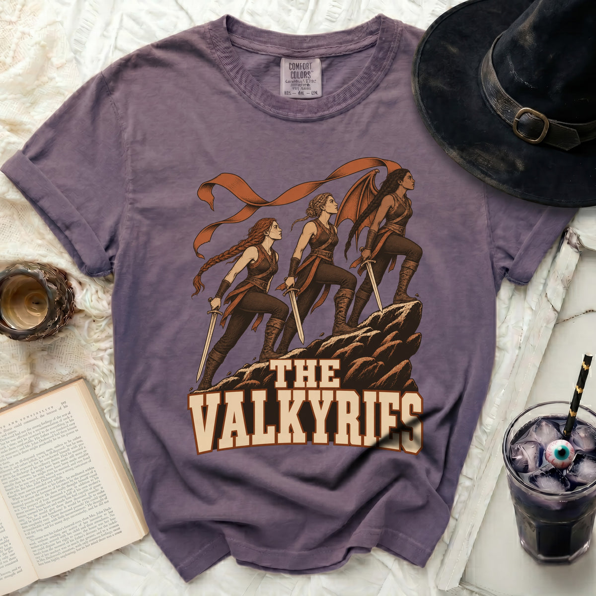 Purple t-shirt with illustration of three Valkyries and text "THE VALKYRIES".