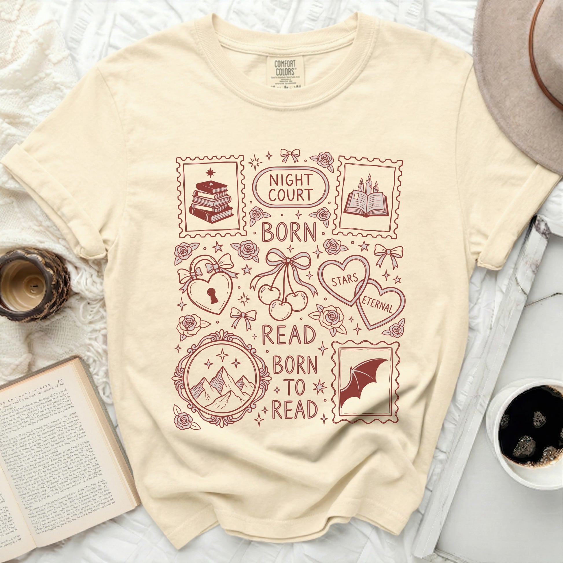 Cream t-shirt with maroon "Night Court", "Born to Read" and book-themed graphics.