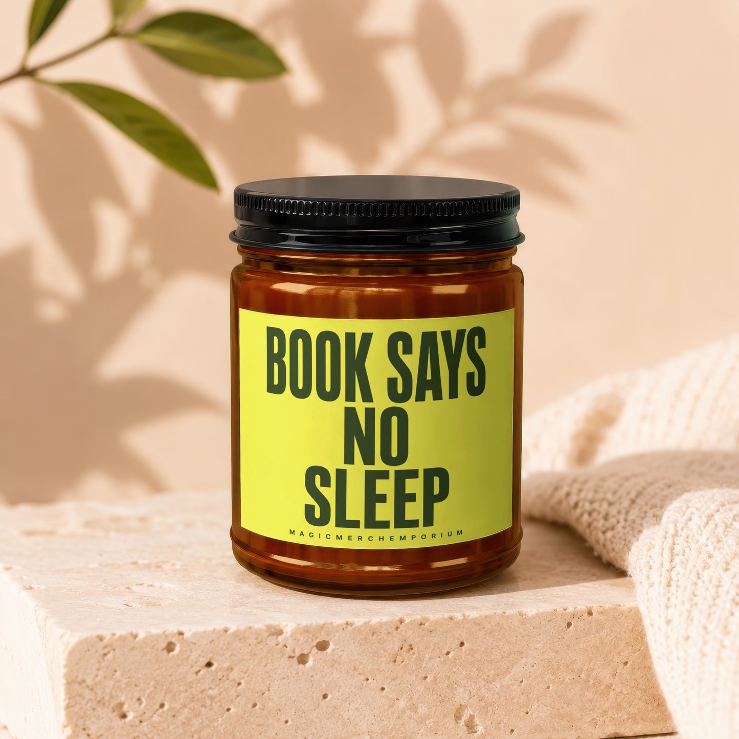 Brown candle with black lid, yellow label reads "BOOK SAYS NO SLEEP".