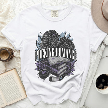 White t-shirt with hockey puck, stick, helmet, and open books graphic