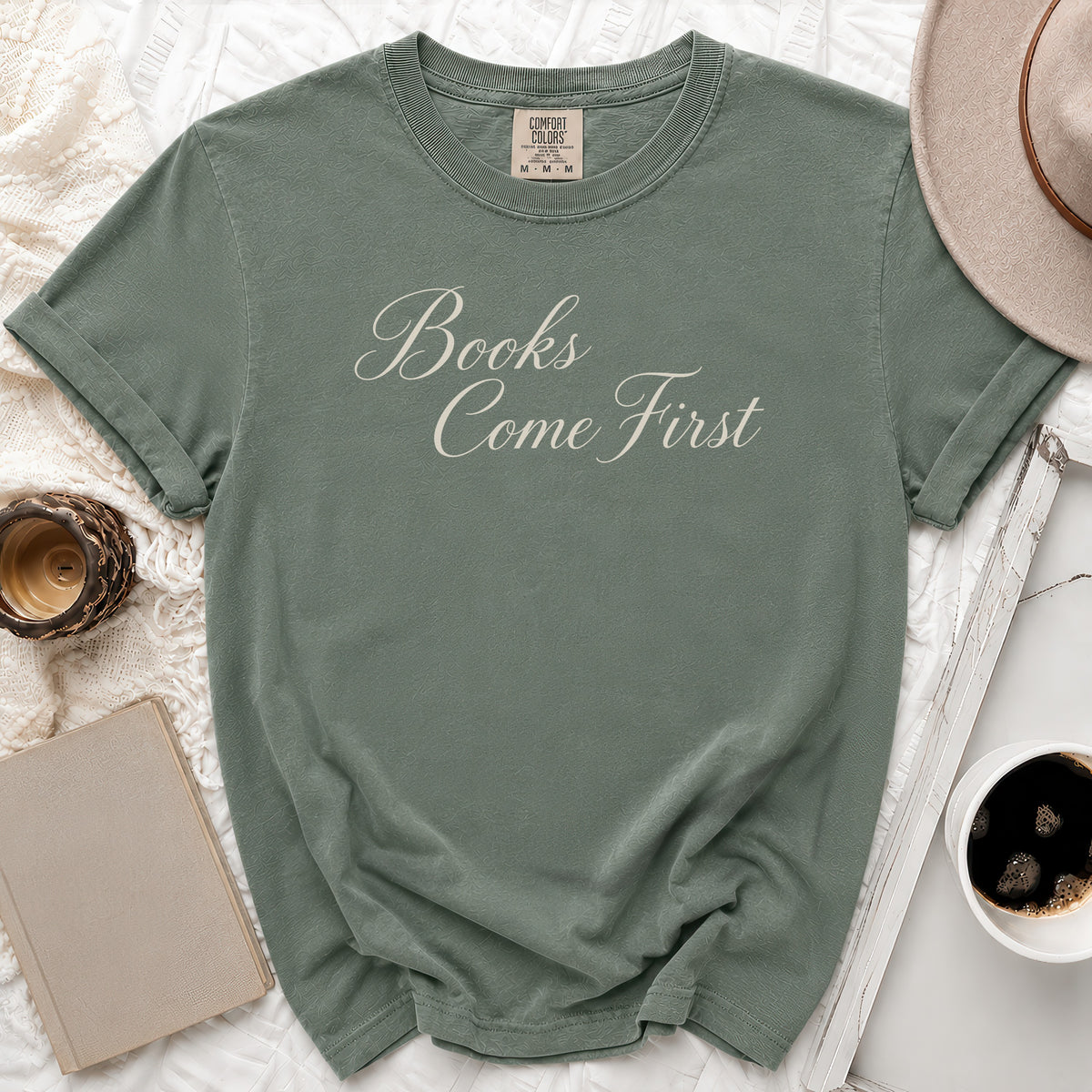 Green t-shirt with "Books Come First" in cursive text, size M.