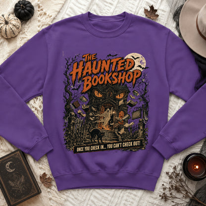 Purple sweatshirt with "The Haunted Bookshop" graphic featuring a haunted house, ghost, and cat.