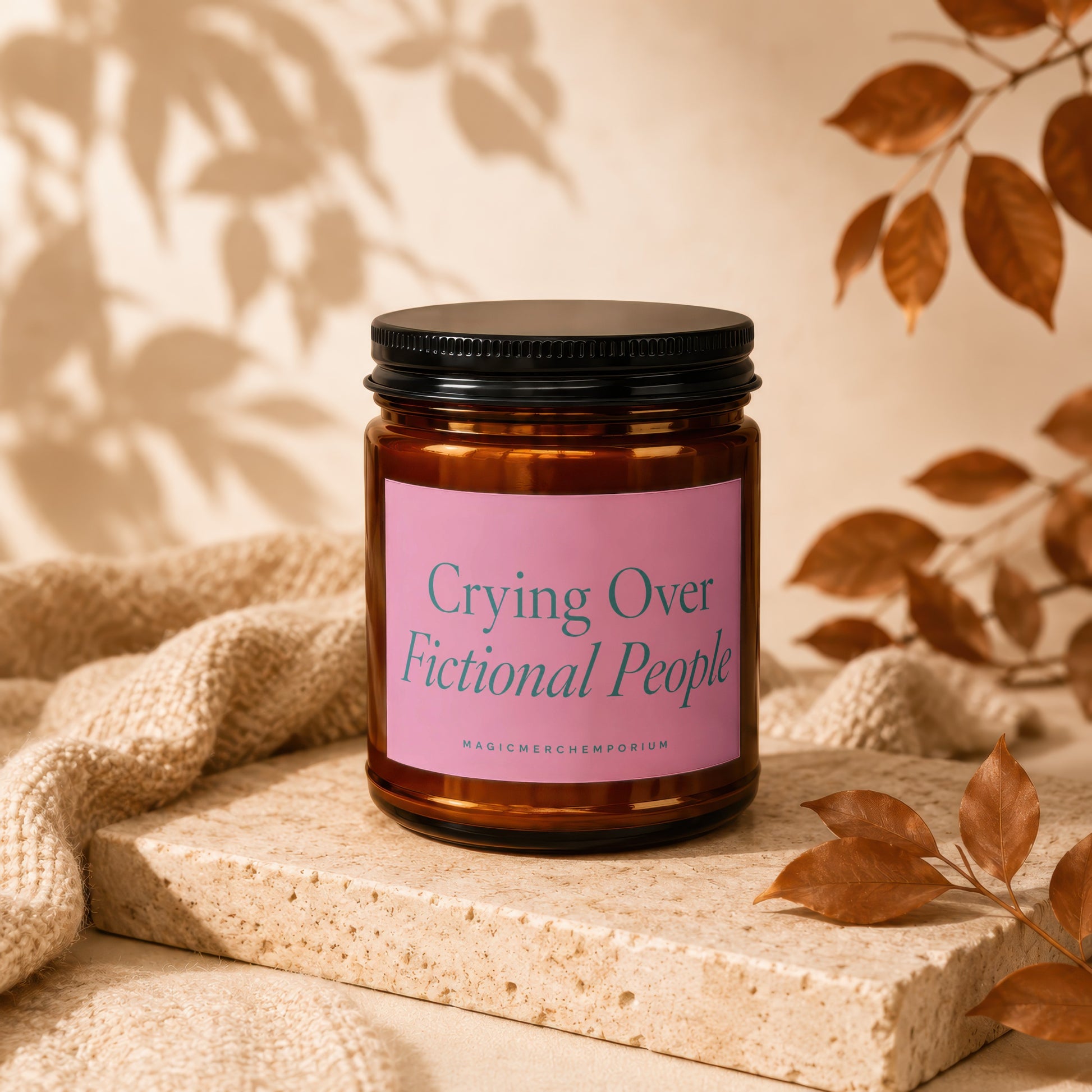 A candle with pink label saying "Crying Over Fictional People".