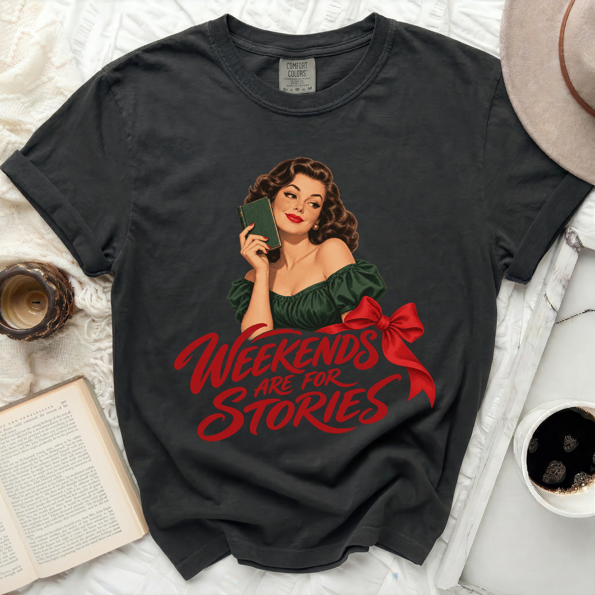 Dark gray t-shirt with graphic of woman reading and text "Weekends are for Stories".